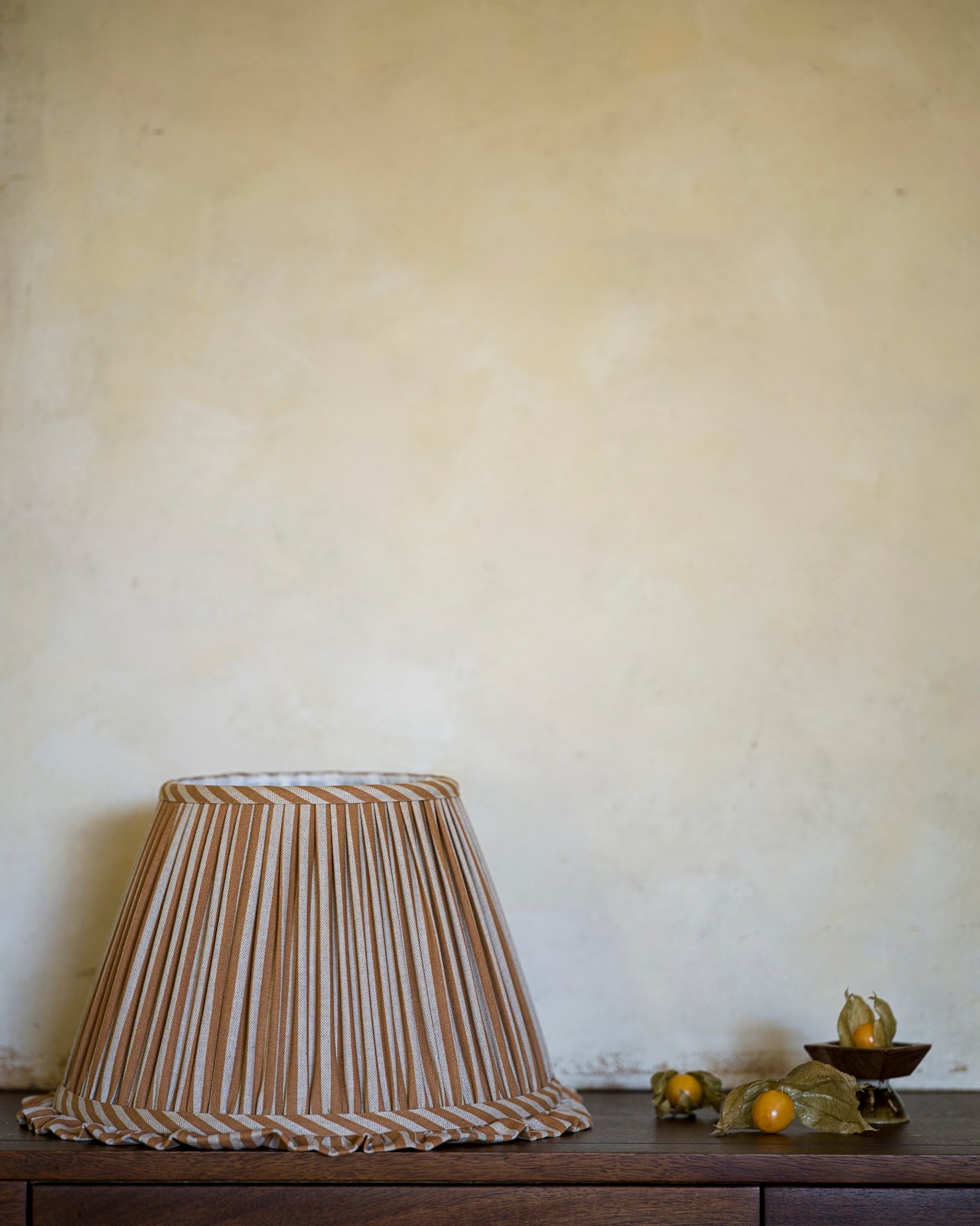 Frilled lampshade in goldenberry on drawers