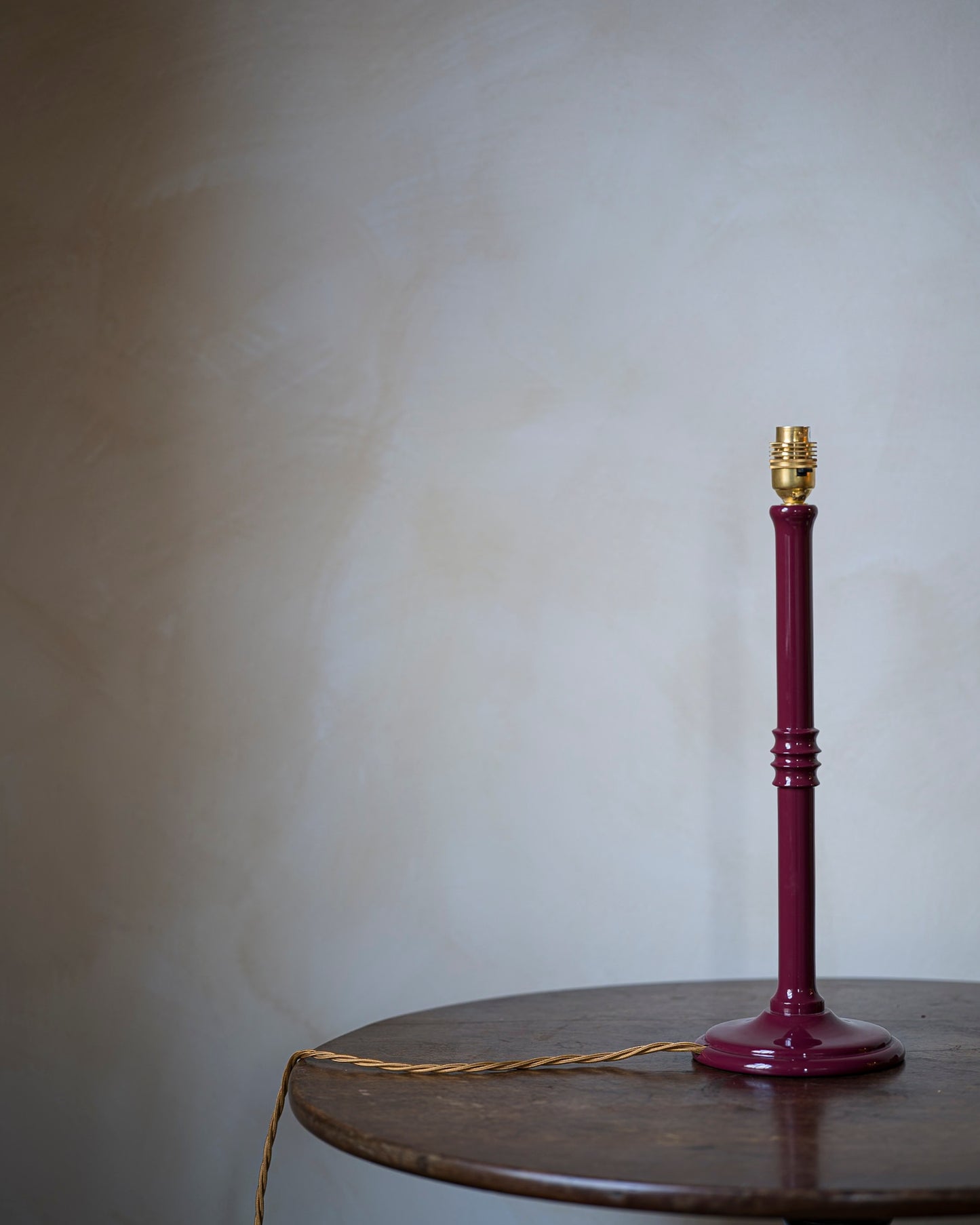 Lacquered lampstand in damson on table