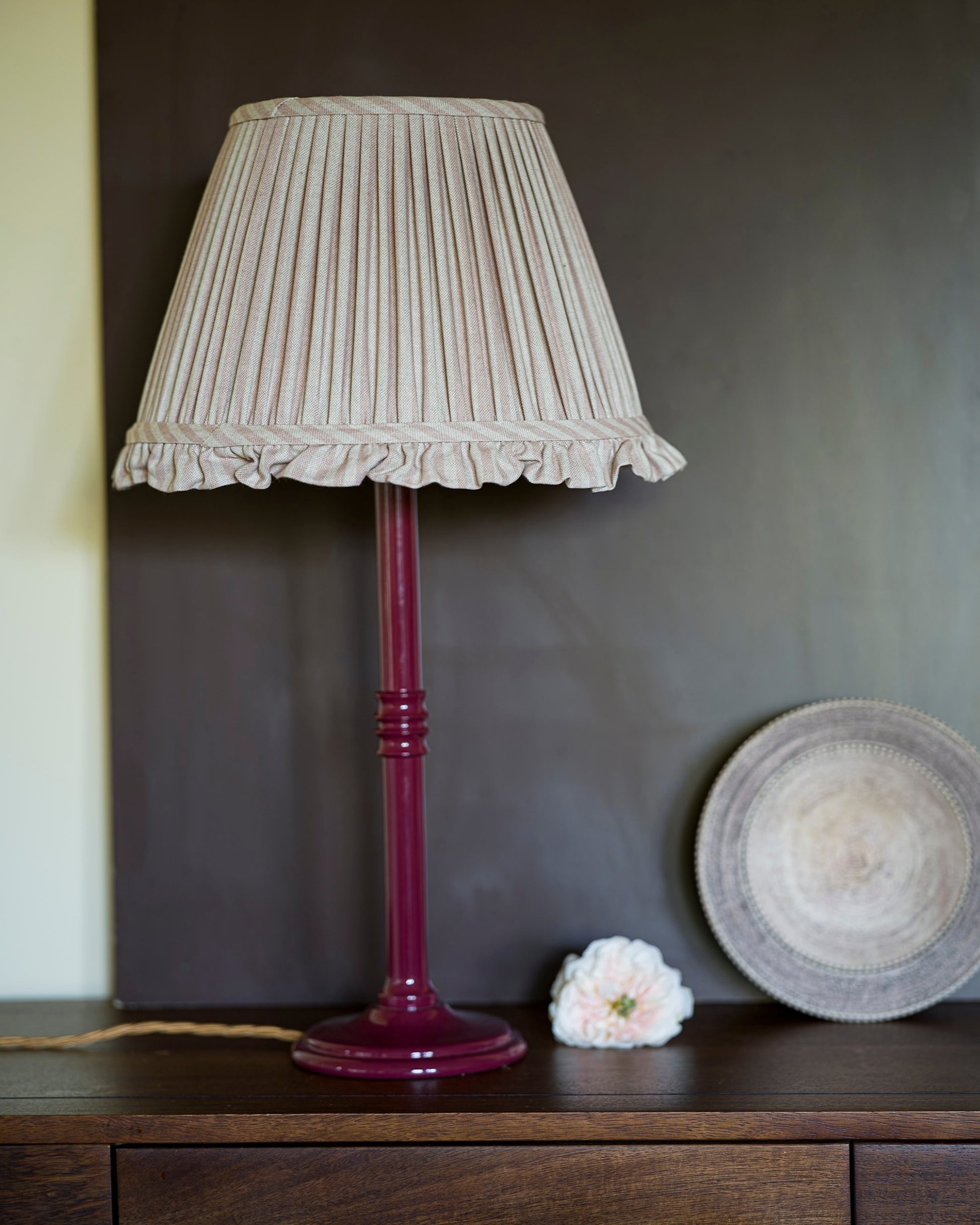 Frilled lampshade in old rose on red lampstand