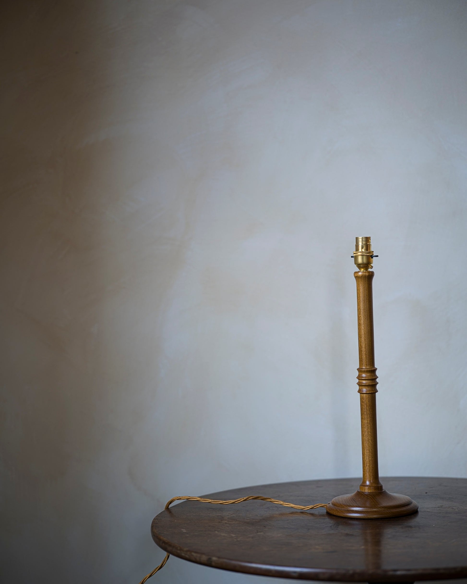 Unlacquered lampstand in wood on table