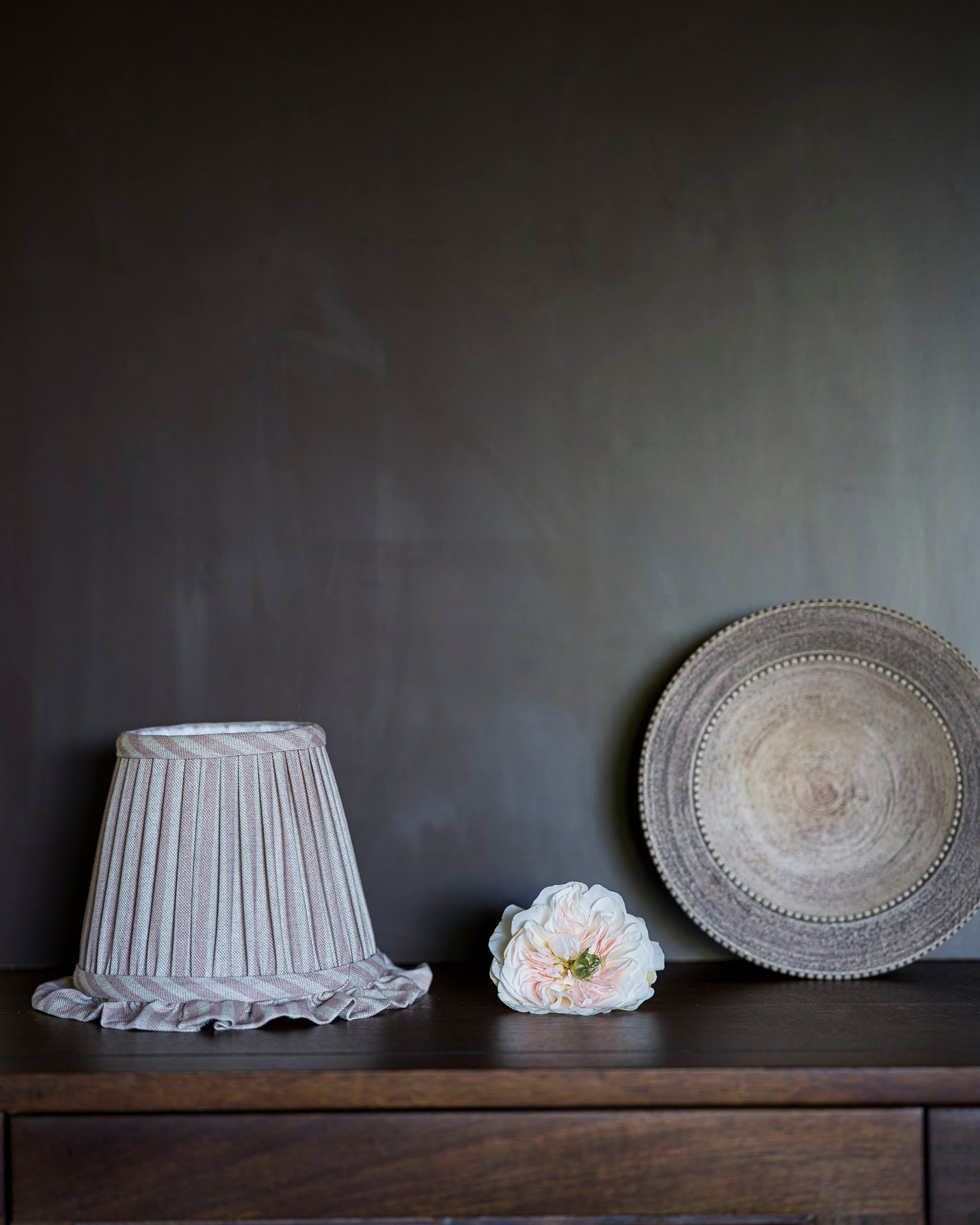 Frilled wall light lampshade in old rose on drawers